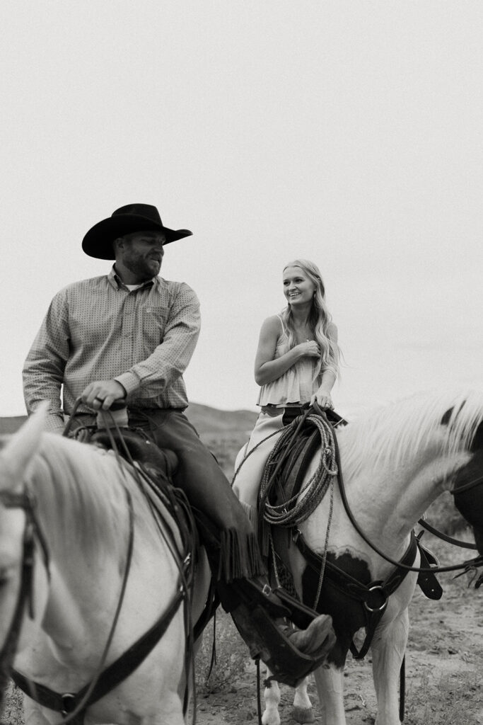 Black and white image of Tyler and Sarah Elrod riding horses