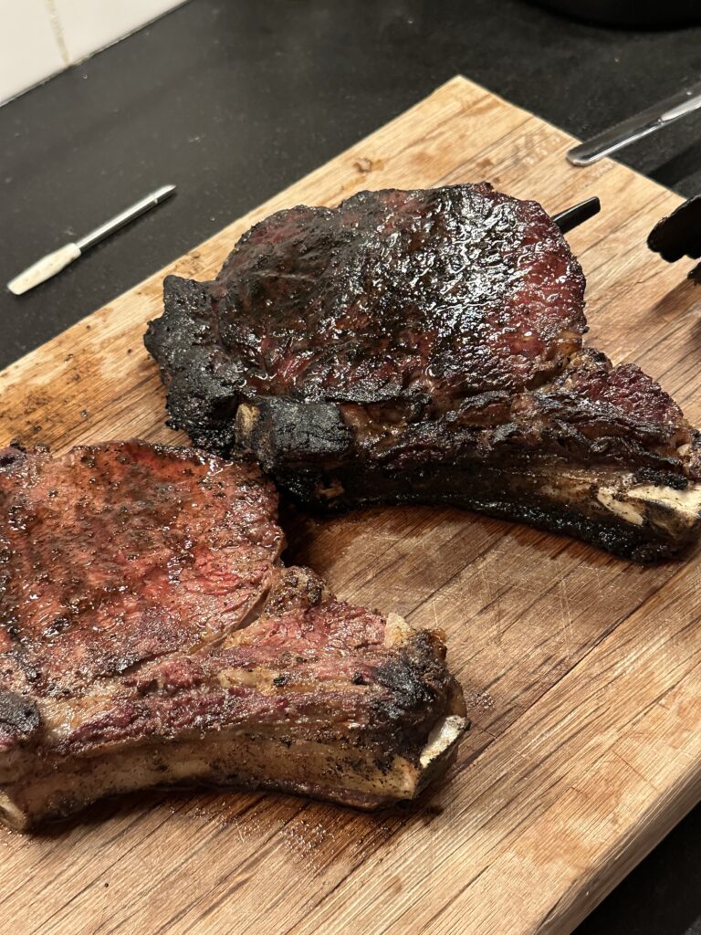 cooked steaks laying on top of a cutting board
