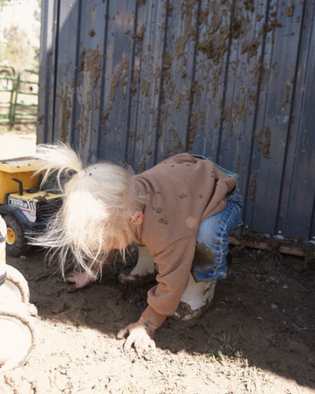 little girl playing in the mud