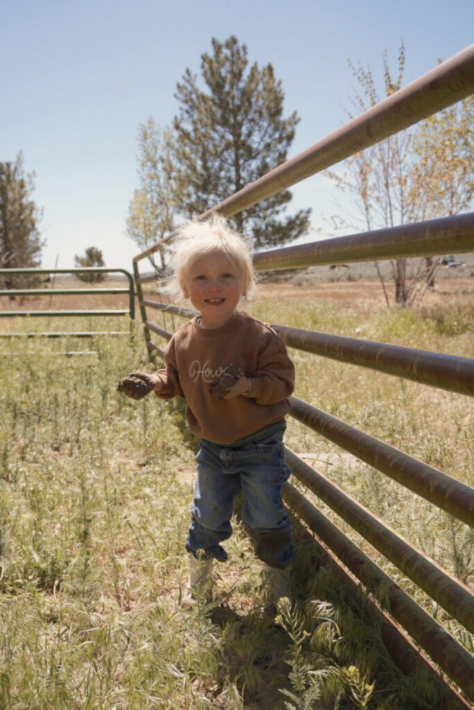 little girl on the homestead playing in mud